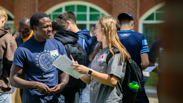 A global partner mentor and an internationals student chat outside on a sunny day