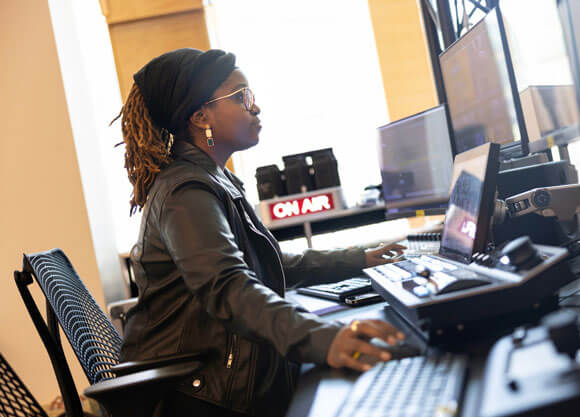 Student in an office looking at a computer screen