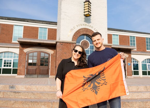 Director of international students services poses with a student on the library steps